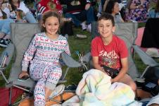 Two kids sitting on some deck chairs on the Carols lawn