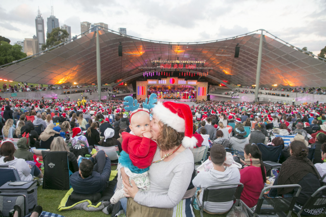 A woman holds a baby on the lawns at the Sidney Myer Music Bowl