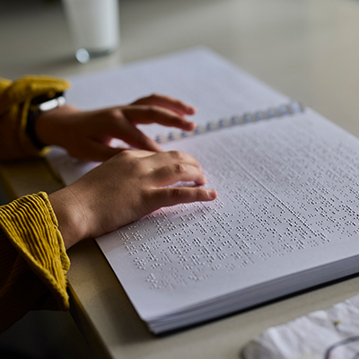 A child's hands reading braille