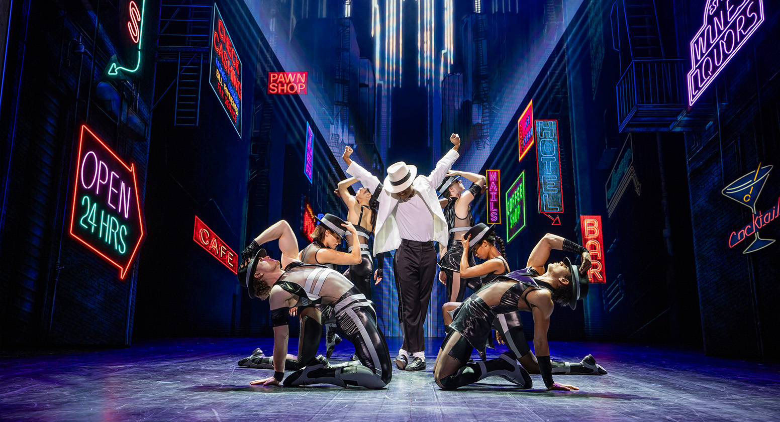 Dancers surround a Michael Jackson figure on a stage