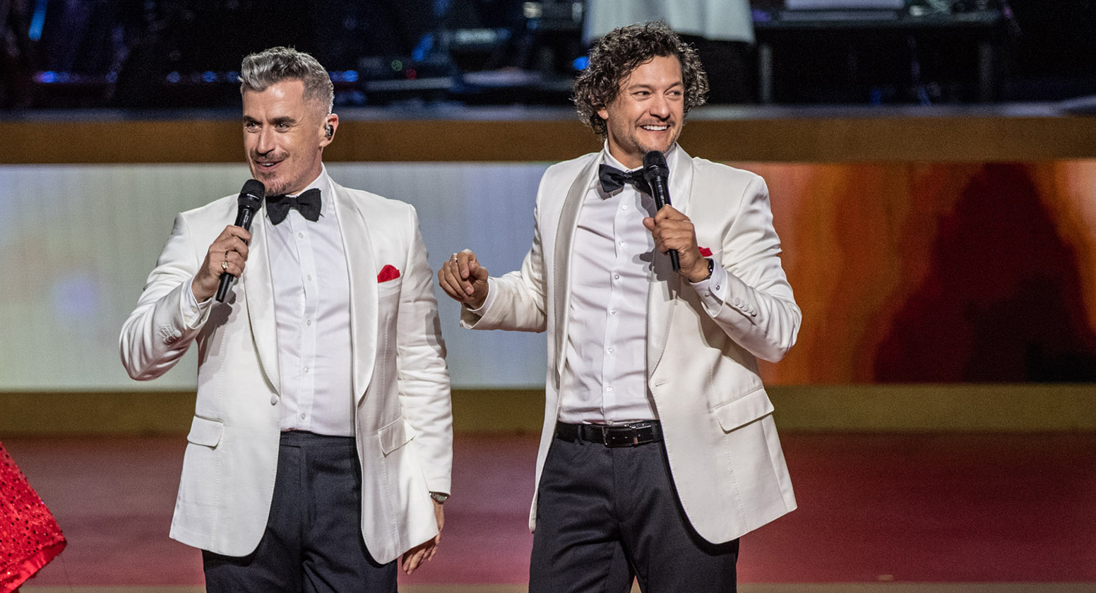 Bobby Fox and Rob Mills wear black and white suits on the Carols stage