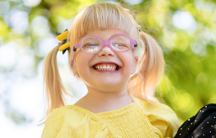 Young girl in yellow, wearing glasses